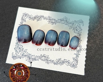 Uñas postizas cortas brillantes reutilizables con efecto ojo de gato en degradado azul medianoche.