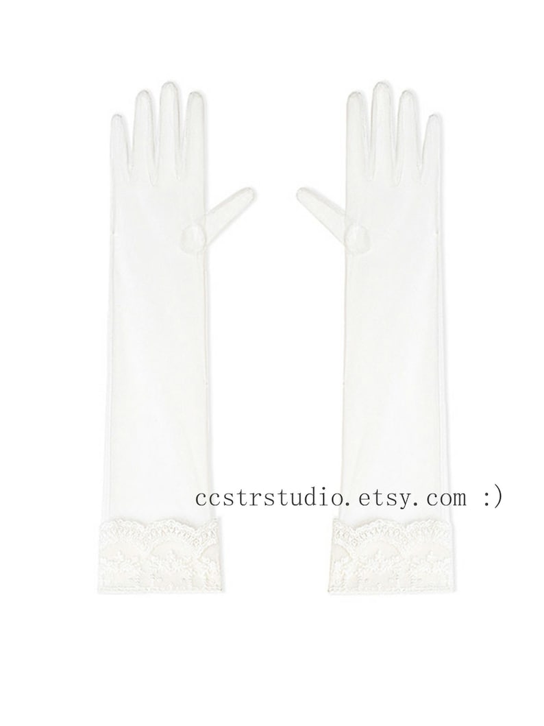 May include: A pair of sheer white opera-length gloves featuring a delicate scalloped lace trim at the wrist. The gloves are translucent and extend to the forearm. The text ccstrstudio. etsy. com :) is printed in black between the two gloves.