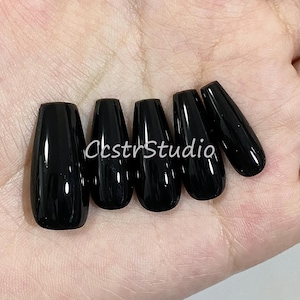 May include: Six black coffin-shaped false nails.