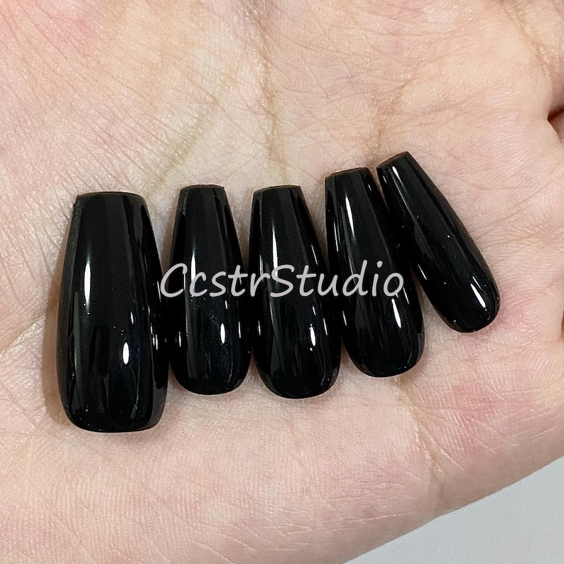 May include: Six black coffin-shaped false nails.