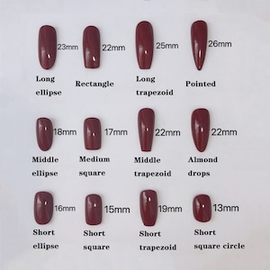 May include: A display of burgundy-colored false nails in various shapes and sizes. Styles include long ellipse (23mm), rectangle (22mm), long trapezoid (25mm), and pointed (26mm). Other shapes are middle ellipse (18mm), medium square (17mm), middle trapezoid (22mm), almond drops (22mm), short ellipse (16mm), short square (15mm), short trapezoid (19mm), and short square circle (13mm).