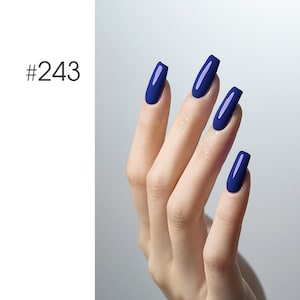 May include: A hand with four nails painted in a deep blue nail polish. The nails are long and oval shaped.