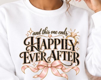 May include: A white crewneck sweatshirt featuring a graphic print with the text and this one ends HAPPILY EVER AFTER, accented by a gold engagement ring illustration and a light pink ribbon bow at the bottom, centered on the chest area.