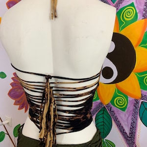 May include: A brown and black halter top with a lace-up back and fringe detail. The top is made of a soft, stretchy fabric and has a relaxed fit.