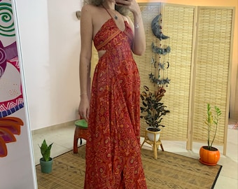 May include: A red maxi dress with a halter neckline and a cut-out design. The dress features a floral print and is made from a lightweight fabric.