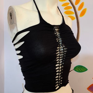May include: Black halter top with a crocheted detail down the front and cutouts on the sides. The top is made of a soft, stretchy fabric.
