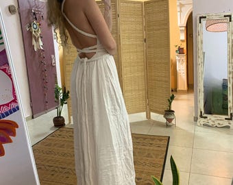 May include: A white maxi dress with a lace-up back and a long, flowing skirt.