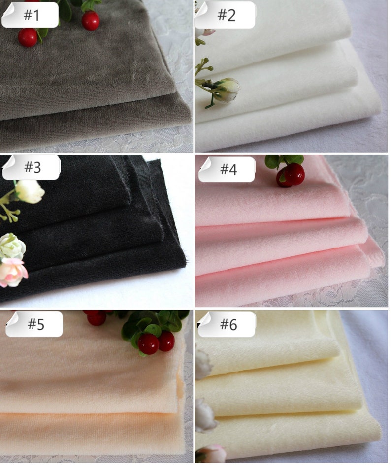 May include: Six samples of fabric in different colors, including gray, white, black, pink, beige, and cream. Each fabric sample is folded and stacked on a white surface. The samples are labeled with numbers 1 through 6.