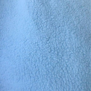 May include: A close-up of a light blue fuzzy fabric. The fabric has a soft, textured surface.