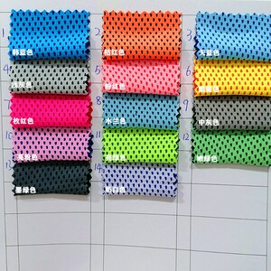 May include: A grid of fabric swatches in various colors, including blue, orange, pink, and green. Each swatch has a perforated texture and is labeled with a Chinese character and color name. The swatches are arranged on a white grid.