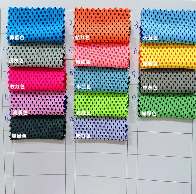 May include: A grid of fabric swatches in various colors, including blue, orange, pink, and green. Each swatch has a perforated texture and is labeled with a Chinese character and color name. The swatches are arranged on a white grid.