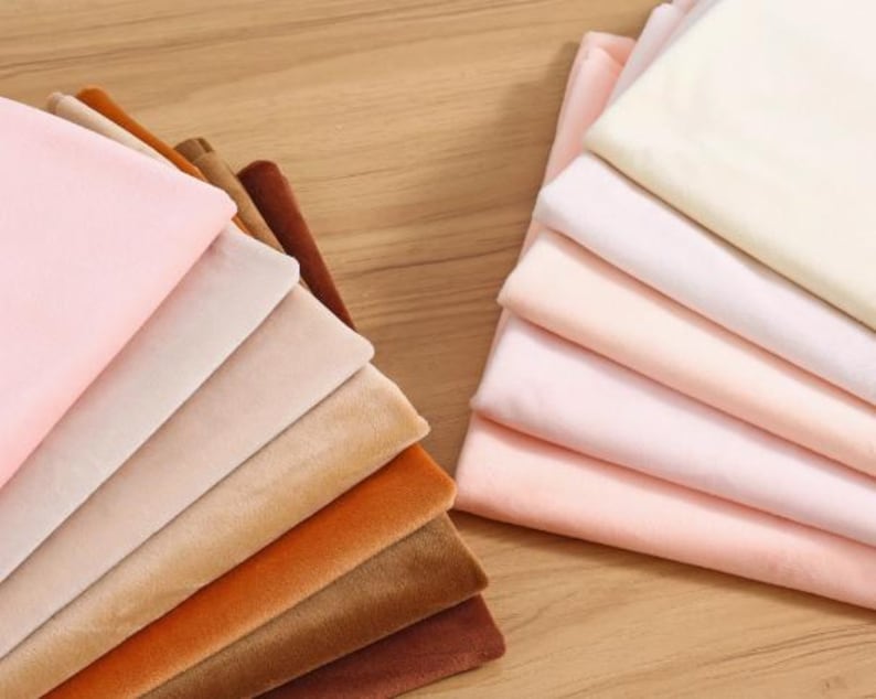 K&ouml;nnte beinhalten: Ein Stapel von 10 verschiedenen farbigen Samtstoffproben. Die Farben sind rosa, beige, braun, orange und dunkelbraun.