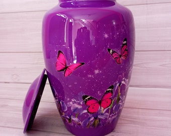 Puede incluir: Urna de cremación de color púrpura con tapa plateada y un diseño de mariposas rosas y flores.