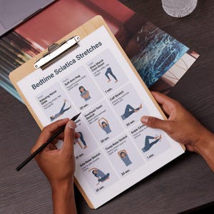 May include: A wooden clipboard displaying a printed guide titled "Bedtime Sciatica Stretches." The guide features illustrated exercises with descriptions. A person's hand holds a pen, pointing at the guide. The clipboard has a silver metal clip.
