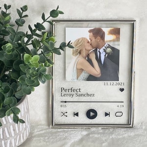 May include: A silver picture frame with a photo of a couple kissing. The frame has a music player design with the text "Perfect Leroy Sanchez" and the date "11.12.2021".