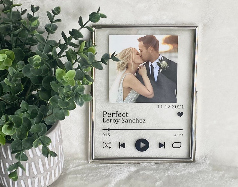 May include: A silver picture frame with a photo of a couple kissing. The frame has a music player design with the text "Perfect Leroy Sanchez" and the date "11.12.2021".