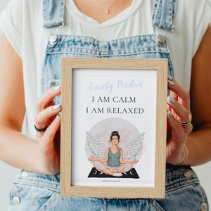 May include: A framed print with a light pink background and a woman with wings meditating. The text reads "Anxiety Mantra I AM CALM I AM RELAXED".