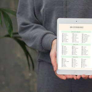 May include: A digital tablet with a white background and green accents displays a checklist titled "My Food List" with categories for vegetables, fruits, and grains. Each category has a list of common food items with checkboxes next to them.
