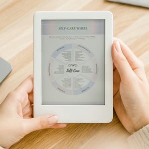 May include: A white tablet with a self-care wheel infographic. The wheel is divided into eight sections, each with a different category of self-care, such as physical, emotional, and spiritual. The text "CWG Self-Care" is in the center of the wheel.