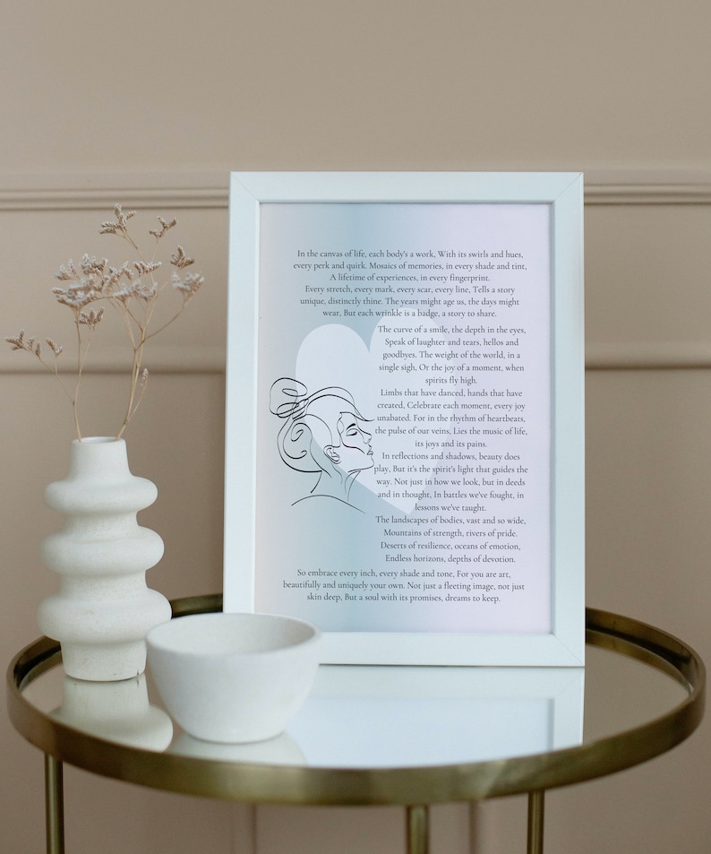 May include: White framed art print with a black and white line drawing of two faces. The print features a quote about life, experiences, and the beauty of each moment. The print is on a table with a white ceramic vase and bowl.