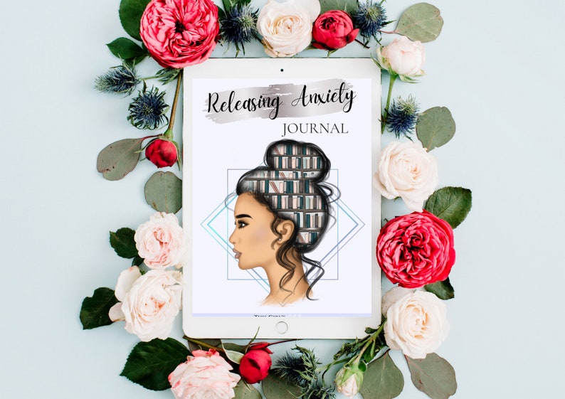 May include: A white tablet with a digital illustration of a woman with a bookshelf inside her head. The text "Releasing Anxiety JOURNAL" is on the tablet. The tablet is surrounded by pink and red roses.