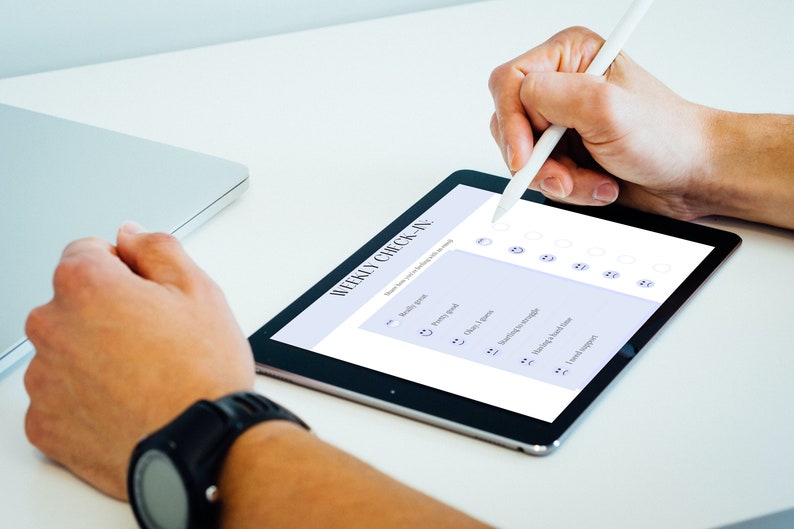 May include: A person uses a stylus to fill out a weekly check-in on a tablet. The check-in includes categories such as "Healthy goal", "Energy level", "Feeling in charge", "Morning struggle", "Past 4 hours", "Need a break", and "Loved support".