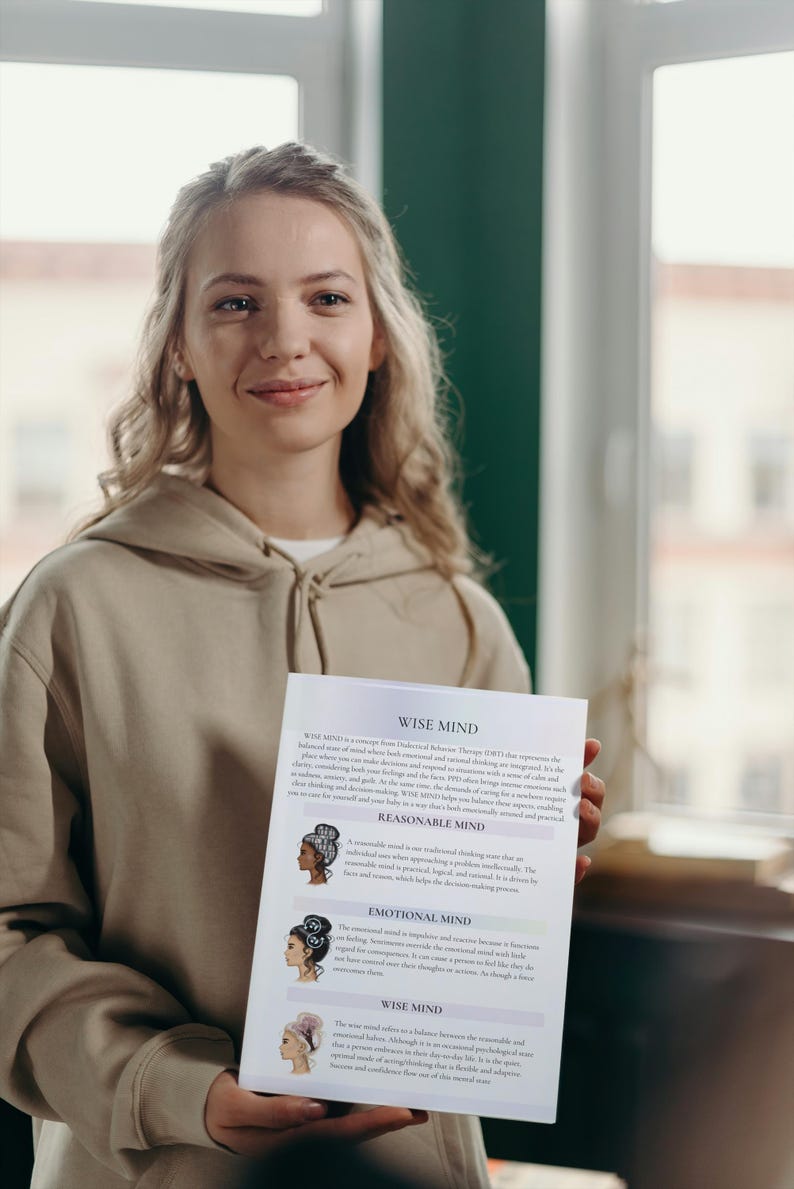 May include: A woman in a beige hoodie holds a white paper with text and illustrations. The paper's title is "WISE MIND" and describes concepts of emotional and rational thinking. The illustrations depict women with different hairstyles.