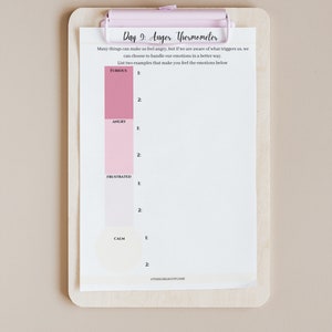 May include: A printable worksheet titled "Day 9: Anger Thermometer" with a pink, white, and grey colour scheme. The worksheet includes a scale of emotions from "Furious" to "Calm" with space to list two examples of what makes the user feel each emotion.