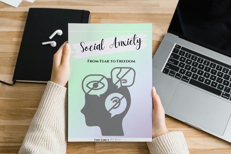 May include: A book cover with the title "Social Anxiety: From Fear to Freedom". The cover features a grey silhouette of a head with three speech bubbles containing icons representing social anxiety, such as a crossed-out eye, a crossed-out mouth, and a crossed-out ear.