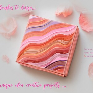 May include: A square box with a pink, orange, and purple abstract design. The box is on a white background with pink flower petals scattered around it. The text "use Brushes to design..." is at the top of the image and the text "...unique idea creative projects..." is at the bottom of the image.