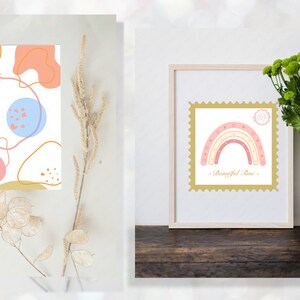 May include: Two framed prints with abstract designs. The first print features a white background with pink, blue, and orange abstract shapes and lines. The second print features a white background with a pink and white rainbow with the text "Beautiful Time" in gold lettering.