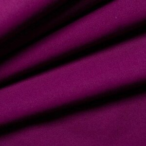 May include: A close-up of a deep purple fabric with a smooth texture. The fabric is folded in a way that shows the drape and flow of the material.