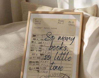 May include: A framed vintage library card with the text "So many books, so little time." The card is in a wooden frame, with a cream-colored background. The text "Grimms' Fairy tales" is also visible.
