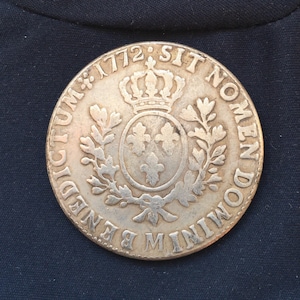 以下が含まれることがあります： 王冠と縁に「SIT NOMIN DOMIN」という文字が刻まれた銀貨。1772年の刻印も見える。