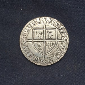 May include: Silver coin with a shield design featuring a cross and various symbols. The coin has a beaded border and the inscription "POSUI DEUM ADIUTOREM MEUM" around the edge.