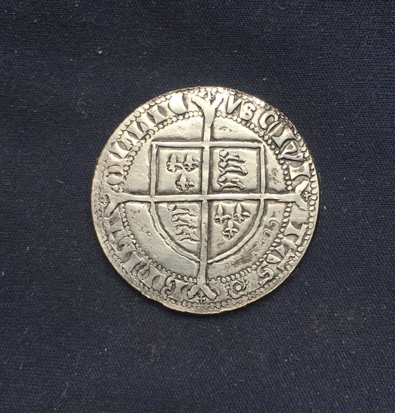May include: Silver coin with a shield design featuring a cross and various symbols. The coin has a beaded border and the inscription "POSUI DEUM ADIUTOREM MEUM" around the edge.