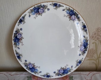 May include: A white ceramic plate with a gold rim and a blue and purple floral design around the edge.