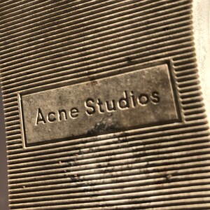 May include: Close-up of the sole of a shoe with the text "Acne Studios" embossed on it.