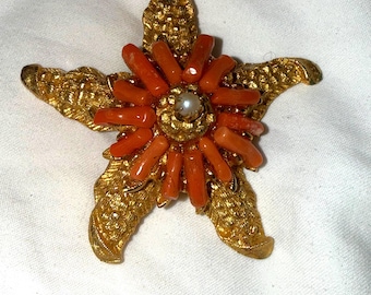 Spilla vintage a forma di stella marina color oro con dettagli in finto corallo e finte perle, di ottime dimensioni e bellissima.