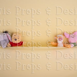 Puede incluir: Cuatro peluches de peluche, incluyendo Winnie de Pooh, Piglet, Eeyore y Tigger, están dispuestos en una fila sobre un fondo amarillo. Todos los juguetes sonríen y tienen los brazos extendidos.