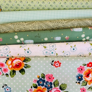 Peut inclure: Une collection de rouleaux de tissu dans diverses nuances de vert et de blanc. Les tissus présentent des motifs floraux, à pois et à carreaux. Certains tissus ont de grands bouquets de roses, d'autres de petits motifs floraux et de bocaux.