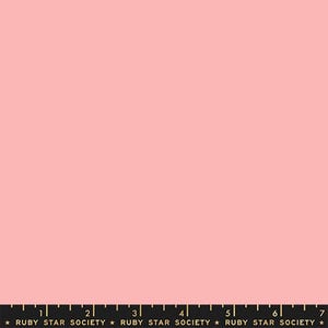 May include: A solid light pink fabric swatch featuring a black selvage edge at the bottom. The selvage includes a printed ruler with white markings from 1 to 7 inches and the repeating gold text Ruby Star Society separated by small stars.