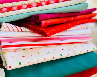May include: A stack of folded fabric pieces in various colors and patterns, including solid teal, red, and magenta, alongside white fabric with red and green candy cane, star, and tree prints, and red and white striped or checkered designs.