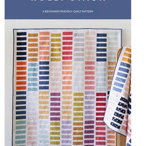 May include: A colorful quilt with a geometric design, featuring vertical rows of various colors including orange, yellow, red, and blue. The quilt is displayed on a white wall, with a second quilt draped over a chair. The text "Cotton and Joy Patterns" and "Rolly Stack" are visible.