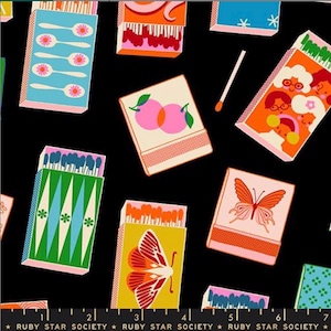 May include: A black background with a repeating pattern of colorful matchboxes. The matchboxes feature various designs, including spoons, peaches, butterflies, and faces. The text "RUBY STAR SOCIETY" is at the bottom.