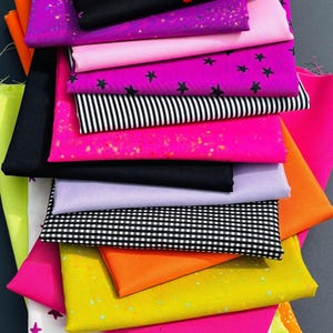 Puede incluir: Una pila de telas dobladas en varios colores y patrones, incluyendo negro con estrellas de neón, rosa fuerte sólido, rayas blancas y negras, cuadros vichy blancos y negros, verde lima sólido, naranja brillante y blanco con estrellas coloridas.