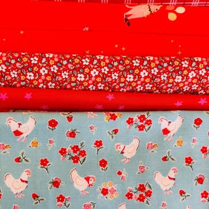 Peut inclure: Une pile de tissus rouges et à motifs variés. Les motifs comprennent des cœurs, des rayures, un chien avec des ballons, des motifs floraux, des étoiles et des poulets avec des fleurs sur fond bleu clair. Idéal pour le patchwork ou les loisirs créatifs.