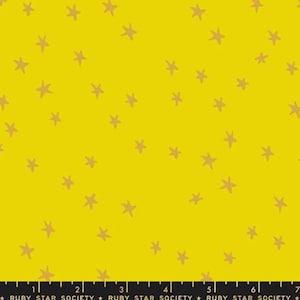 May include: Bright yellow fabric featuring a random arrangement of tan stars. The stars are of varying sizes and shapes, set against a solid yellow backdrop. The text "RUBY STAR SOCIETY" is at the bottom of the fabric.