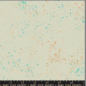 May include: Cream-colored fabric with a speckled pattern of teal, orange, and gold dots. The fabric has a subtle texture and is suitable for various sewing projects. The text "RUBY STAR SOCIETY" is printed at the bottom.