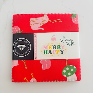 May include: A stack of 42 red fabric squares, each 5 inches, with holiday-themed illustrations. A white band wraps the stack, displaying "MERRY HAPPY" and "by Kimberly Kight". The Ruby Star Society logo is also visible.